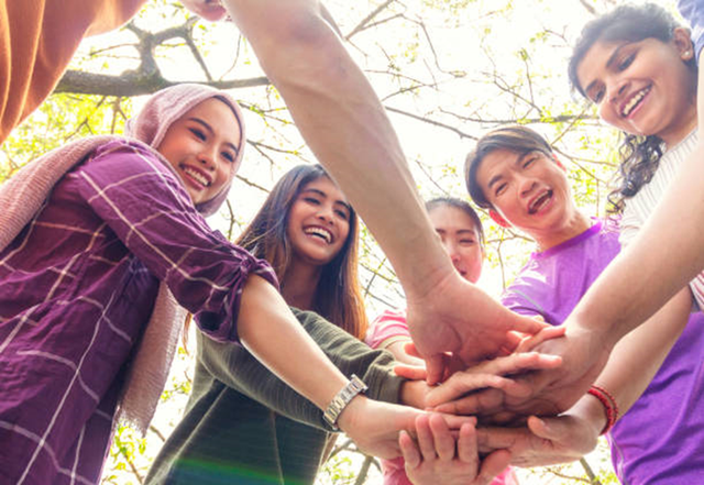 kelompok teman multi etnis menumpuk tangan dalam kerumunan bersama. Persaudaraan manusia, harmoni dan konsep persatuan. Sumber : Istockphoto.com