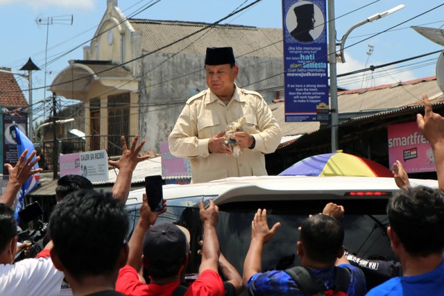 Capres Nomor urut 2 Prabowo Subianto membagikan kaos kepada masyarakat usai berziarah ke Makam Presiden Soekarno di Blitar, Jawa Timur, MInggu (17/12/2023). Foto: Irfan Anshori/Antara Foto
