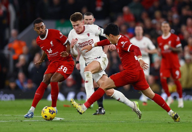 Scott McTominay (tengah) dijegal Ryan Gravenberch dan Wataru Endo dalam pertandingan Liga Inggris 2023/24 antara Liverpool vs Manchester United di Stadion Anfield, Minggu (17/12). Foto: Molly Darlington/Reuters