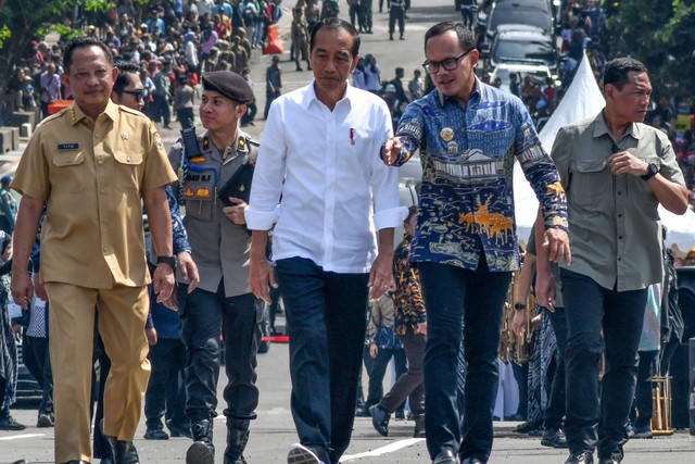 Presiden Jokowi (tengah) didampingi Wali Kota Bogor Bima Arya (kedua kanan) dan Menteri Dalam Negeri Tito Karnavian (kiri) berjalan bersama menuju lokasi peresmian jembatan Otista, Kota Bogor, Jawa Barat, Selasa (19/12/2023). Foto: Arif Firmansyah/ANTARA FOTO