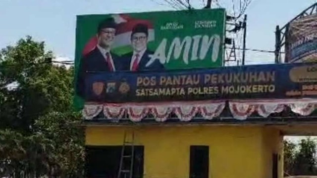 Dua APK milik dua pasangan Calon Presiden (Capres) dan Calon Wakil Presiden (Cawapres) yang berada di baliho tepat di atas dua pos polisi.  Foto: Dok. Istimewa