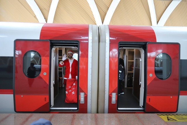 Seorang karyawan KCIC (Whoosh) mengenakan kostum sinterklas membagikan hadiah kepada penumpang di Stasiun Kereta Cepat Indonesia China Halim, Jakarta, Minggu (24/12/2023).  Foto: Iqbal Firdaus/kumparan