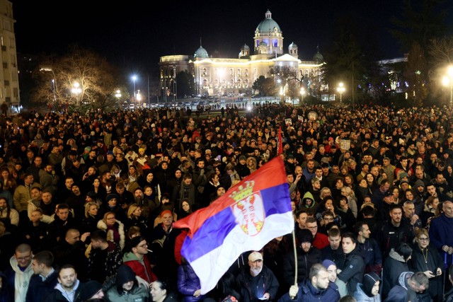 Para pengunjuk rasa berkumpul di depan gedung dewan kota Beograd selama demonstrasi di Beograd, Serbia, Minggu (24/12/2023). Foto: OLIVER BUNIC / AFP