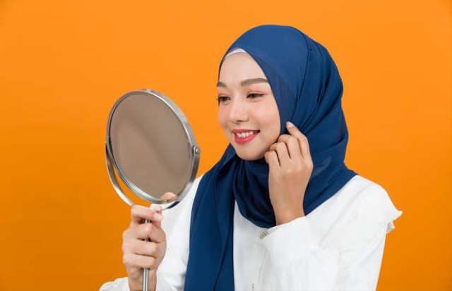https://media.istockphoto.com/id/1338682896/id/foto/wanita-muslim-muda-asia-mengenakan-jilbab-tersenyum-dan-melihat-cermin-pada-latar-belakang.jpg?s=612x612&w=0&k=20&c=lNKIQm-dm1e-QLPmyE78zBc0b2HRjOJgMQUEtUmdf2E=