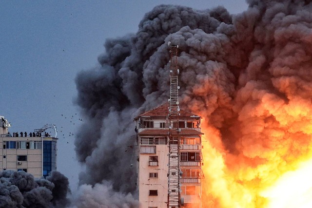 Api dan asap membubung di atas gedung-gedung selama serangan udara Israel di Kota Gaza, pada 7 Oktober 2023. Foto: MAHMUD HAMS / AFP