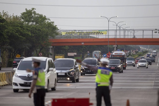 Personel Satlantas Polres Cirebon Kota mengatur lalu lintas kendaraan yang melintas jalan tol Cipali, Palimanan, Cirebon, Jawa Barat, Selasa (26/12/2023). Foto: Dedhez Anggara/ANTARA FOTO