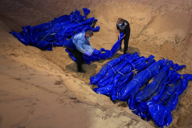 Mayat warga Palestina yang terbunuh di Gaza utara, dimakamkan di kuburan massal di Rafah, di Jalur Gaza selatan, Selasa (26/12/2023). Foto: Mahmud Hams/AFP