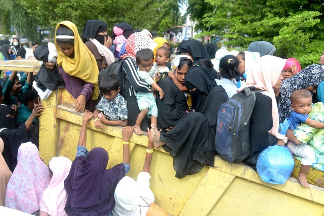 Sejumlah imigran etnis Rohingya naik ke truk saat berlangsung pemindahan paksa di penampungan sementara gedung Balai Meuseuraya Aceh (BMA), Banda Aceh, Aceh, Rabu (27/12/2023). Foto: Ampelsa/ANTARA FOTO