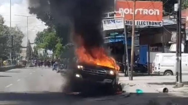 Sebuah mobil yang dibakar saat arak-arakan jenazah Lukas Enembe oleh masyarakat dari Bandara Sentani ke STAKIN, Kamis (28/12/2023). Foto: Dok. Istimewa