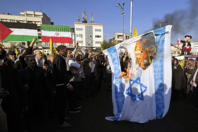 Warga Iran membakar bendera Israel saat protes di Teheran untuk mendukung warga Palestina di Gaza pada 18 November 2023. Foto: AFP