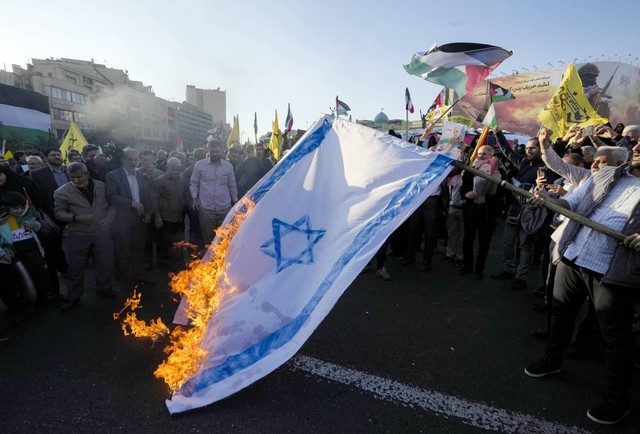 Warga Iran membakar bendera Israel saat protes di Teheran untuk mendukung warga Palestina di Gaza pada 18 November 2023. Foto: AFP