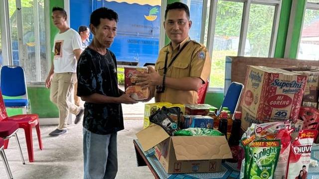 Kepala Dinas Sosial Kabupaten Sitaro, Cosman Ambalao, saat menyerahkan bantuan kepada warga penerima.