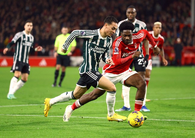 Antony Dos Santos duel dengan Ola Aina saat laga Nottingham Forest vs Manchester United dalam lanjutan Liga Inggris di Stadion City Ground pada Minggu (31/12) dini hari WIB. Foto: REUTERS/Molly Darlington