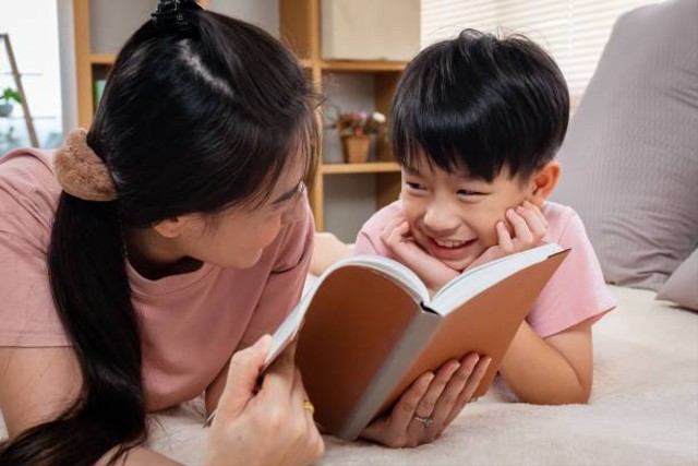 Seorang ibu membacakan dongeng kepada buah hati. Foto: https://www.istockphoto.com/id/foto/ibu-dan-anak-lajang-asia-mengenakan-t-shirt-merah-muda-mereka-berdua-berbaring-dengan-gm1418784519-465357263