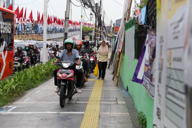 Kendaraan bermotor melintasi trotoar jalur pejalan kaki di kawasan Matraman, Jakarta, Selasa (2/1/2024). Foto: Iqbal Firdaus/kumparan