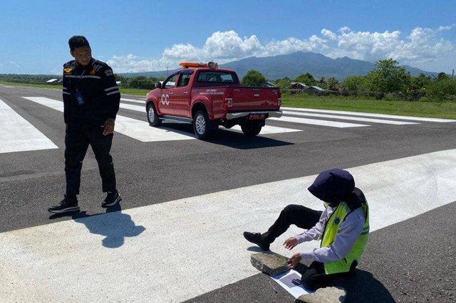 Petugas melakukan aktivitas pengujian abu vulkanik dengan paper test di landasan pacu Bandara Frans Seda Maumere, Sikka, NTT, Selasa (2/1/2024). Foto: Bandara Frans Seda Maumere