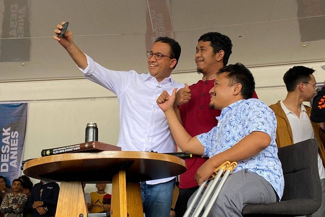 Capres nomor urut 01 Anies Baswedan berswafoto dengan dua penyandang disabilitas. Foto: kumparan