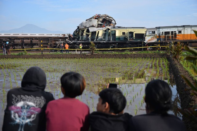 Sejumlah warga melihat kereta api lokal Bandung Raya yang bertabrakan dengan kereta api Turangga di Cicalengka, Kabupaten Bandung, Jawa Barat, Jumat (5/1/2024). Foto: ANTARA FOTO/Raisan Al Farisi