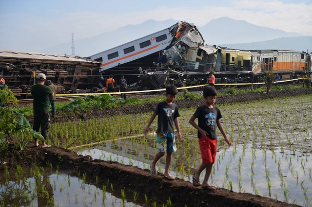 Sejumlah warga melihat kereta api lokal Bandung Raya yang bertabrakan dengan kereta api Turangga di Cicalengka, Kabupaten Bandung, Jawa Barat, Jumat (5/1/2024). Foto: ANTARA FOTO/Raisan Al Farisi