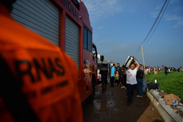 Sejumlah penumpang mengevakuasi barangnya saat terjadinya tabrakan kereta api lokal Bandung Raya yang bertabrakan dengan kereta api Turangga di Cicalengka, Kabupaten Bandung, Jawa Barat, Jumat (5/1/2024). Foto: ANTARA FOTO/Raisan Al Farisi