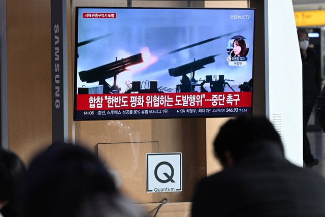 Orang-orang menonton layar televisi yang menayangkan siaran berita dengan rekaman penembakan artileri Korea Utara, di stasiun kereta api di Seoul, Korsel, Jumat (5/1/2024). Foto: Jung Yeon-je/AFP