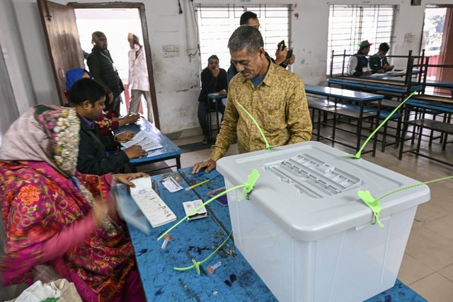 Seorang pria menunggu untuk menerima surat suaranya sebelum memberikan suara dalam pemilihan umum Bangladesh di Dhaka pada 7 Januari 2024. Foto: INDRANIL MUKHERJEE / AFP