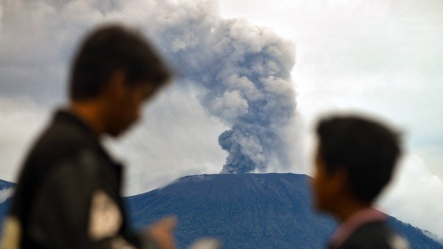 Warga berbincang saat Gunung Marapi mengeluarkan abu vulkanik yang terlihat dari kaki Gunung Singgalang, Nagari Pandai Sikek, Tanah Datar, Sumatera Barat, Minggu (7/1/2024). Foto: ANTARA FOTO/Iggoy el Fitra