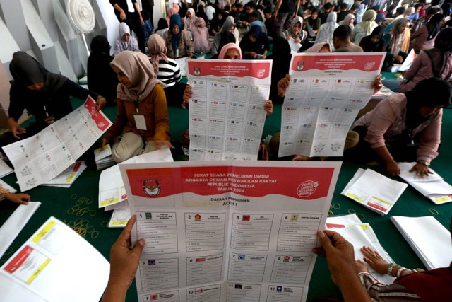 Pekerja menyortir dan melipat surat suara DPR pada Pemilu serentak 2024 di gedung Information Technology Learning Center (ITLC), Banda Aceh, Aceh, Minggu (7/1/2024). Foto: ANTARA FOTO/Irwansyah Putra