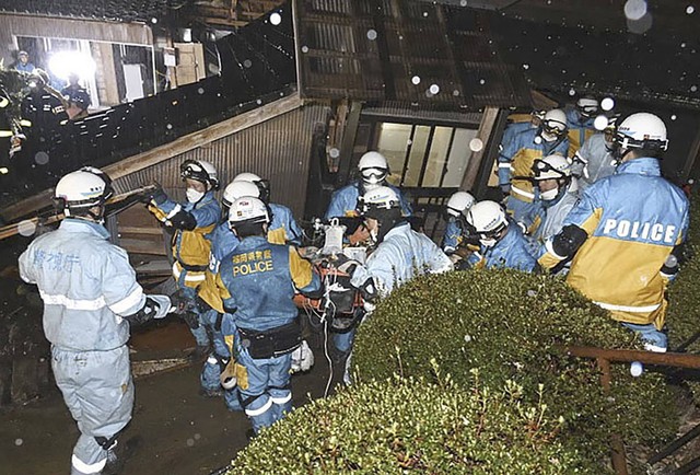 Petugas polisi menyelamatkan seorang wanita berusia 90-an dari rumah yang runtuh di Suzu, prefektur Ishikawa, Jepang, Sabtu, 6 Januari 2024. Foto: Departemen Kepolisian Metropolitan/Berita Kyodo melalui AP