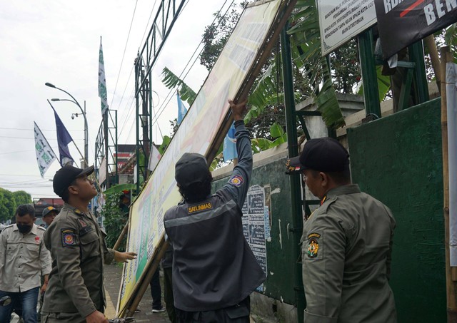 Ilustrasi petugas Satpol PP Kota Yogya tengah mencopot APK-APK melanggar aturan di Kota Yogya. Foto: Dok. Pemkot Yogya