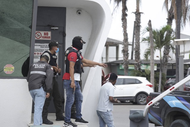 Polisi mengevakuasi staf stasiun saluran televisi TC setelah sekelompok pria bersenjata menerobos masuk ke lokasi syuting saat siaran langsung, di Guayaquil, Ekuador, Selasa, 9 Januari 2024. Foto: AP/Cesar Munoz