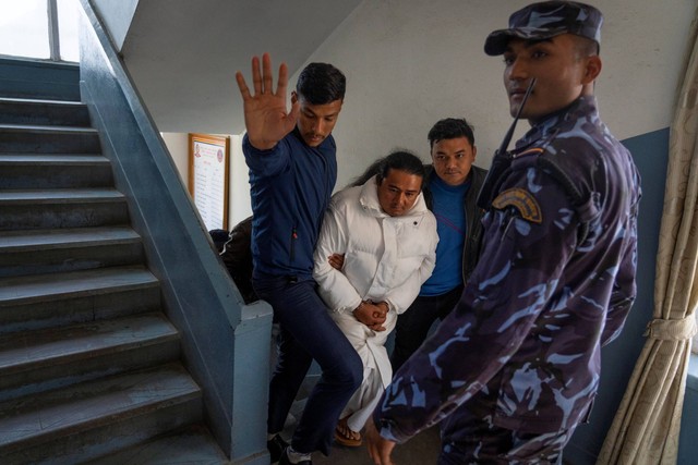 Pemimpin spiritual kontroversial yang diborgol Ram Bahadur Bomjan terlihat saat konferensi pers di Biro Investigasi Pusat setelah dia ditangkap di Kathmandu, Nepal, Rabu (10/1/2024). Foto: Niranjan Shrestha/AP Photo