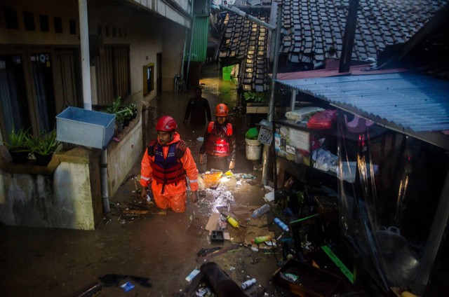 Petugas SAR melewati banjir di permukiman padat Braga, Bandung, Jawa Barat, Kamis (11/1/2024). Foto: Novrian Arbi/Antara Foto