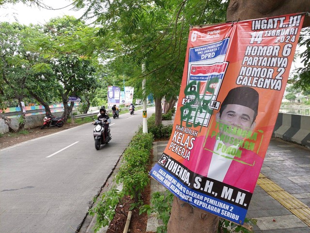 Spanduk caleg yang terpasang di pohon di wilayah Koja, Jakut, dicoret dengan tulisan 'tersangka penusukan pohon', Jumat (12/1). Foto: Fachrul Irwinsyah/kumparan