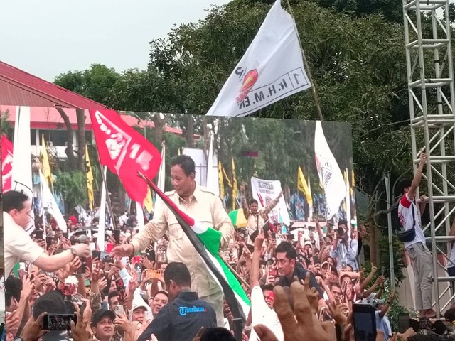 Momen Prabowo cium bendera palestina dan lepas baju di atas panggung saat kampanye di GOR Temenggung, Batam, Kepulauan Riau, Sabtu (13/1). Foto: Zamachsyari/kumparan