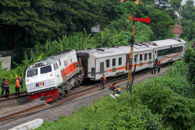 Petugas berada di samping kereta api yang anjlok di emplasemen Stasiun Tanggulangin, Sidoarjo, Jawa Timur, Minggu (14/1/2024). Foto: Umarul Faruq/ANTARA FOTO