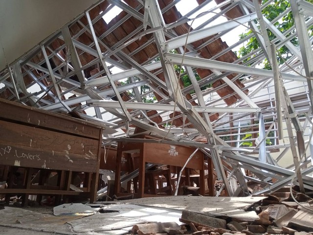 Kondisi atap baja ringan bangunan kelas yang ambruk di SMPN 2 Greged tampak ringsek menimpa meja dan kursi belajar siswa. Foto: Tarjoni/Ciremaitoday