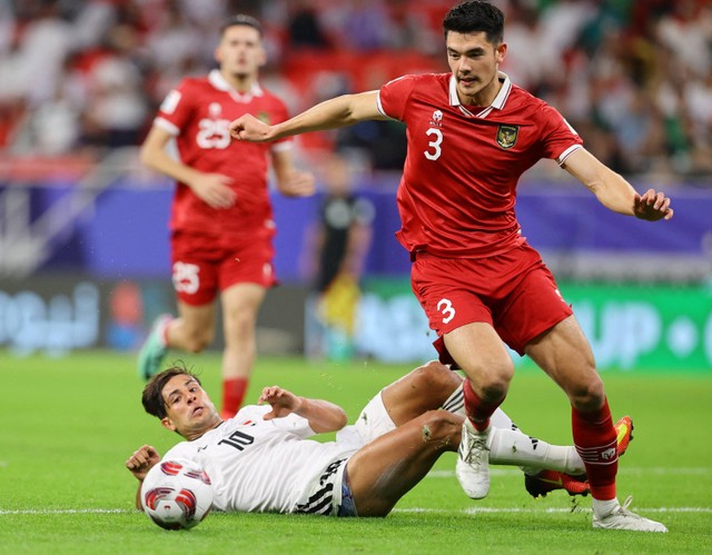 Elkan Baggott dari Indonesia duel dengan Mohanad Ali dari Irak saat pertandingan Piala Asia AFC Grup D di Stadion Ahmad bin Ali, Al Rayyan, Qatar. Foto: Ibraheem Al Omari/Reuters