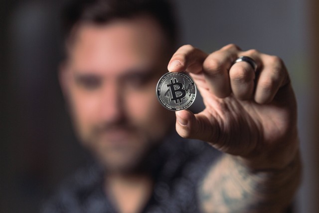 sumber: https://www.pexels.com/photo/person-holding-silver-bitcoin-coin-1447418/