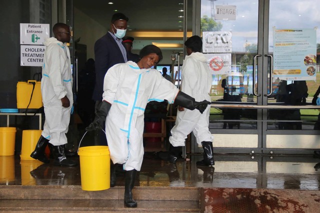 Seorang pekerja membawa seember penuh disinfektan di pusat pengobatan kolera, di Lusaka, Zambia, Jumat, 12 Januari 2024. Foto: AP Photo
