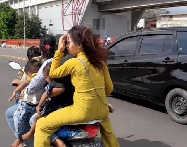 Tangkap layar dari video emak-emak naik motor bonceng tujuh tanpa mengenakan helm di Jembatan Ampera Palembang