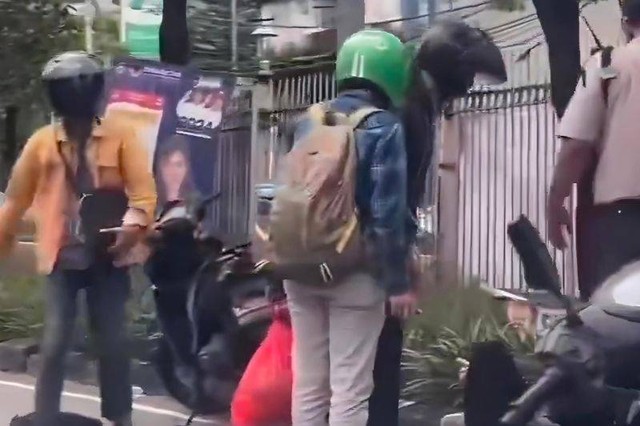 Pengendara motor tertimpa baliho atau alat peraga kampanye (APK) caleg saat sedang melintas di jalur bus TransJakarta di Jalan Daan Mogot, Jakarta Barat, Sabtu, (20/1). Foto: Ilham Kausar