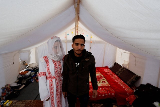 Pasangan Palestina, Mohammed Al-Ghandour dan istrinya Shahad saat hari pernikahan mereka di tenda pengungsian di Rafah, Jalur Gaza, Kamis (18/1/2024). Foto: Mohammed Salem/Reuters