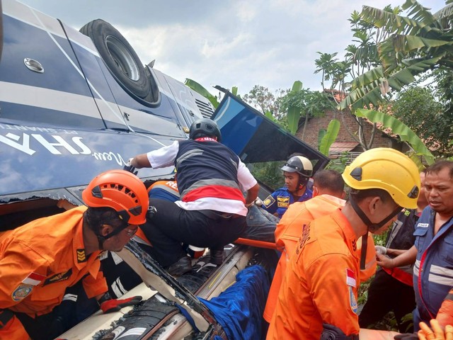 Petugas saat mengevakuasi korban kecelakan bus yang terjun di Tol Batang-Pemalang. Foto: Basarnas