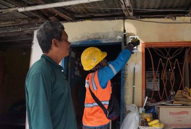 Petugas PLN sedang melakukan pemeliharaan meteran listrik warga. Foto: istimewa