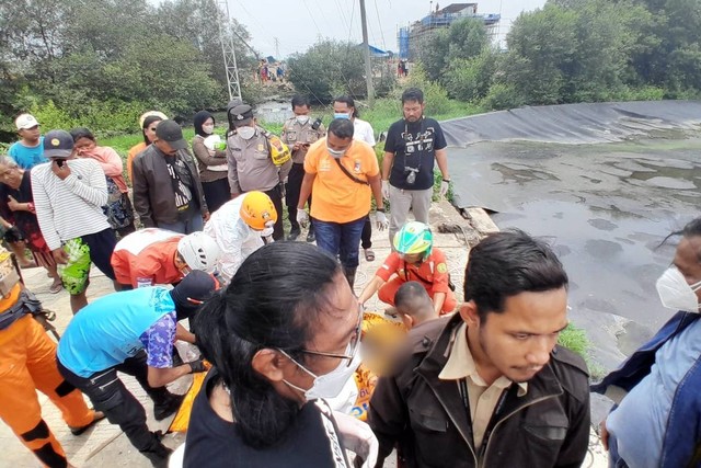 Petugas saat mengevakuasi mayat pria yang mengenakan baju bewarna oranye dengan tulisan Bawaslu di Instalasi Pengolahan Limbah Tinja (IPLT) di Genuk, Kota Semarang. Foto: Dok. Istimewa