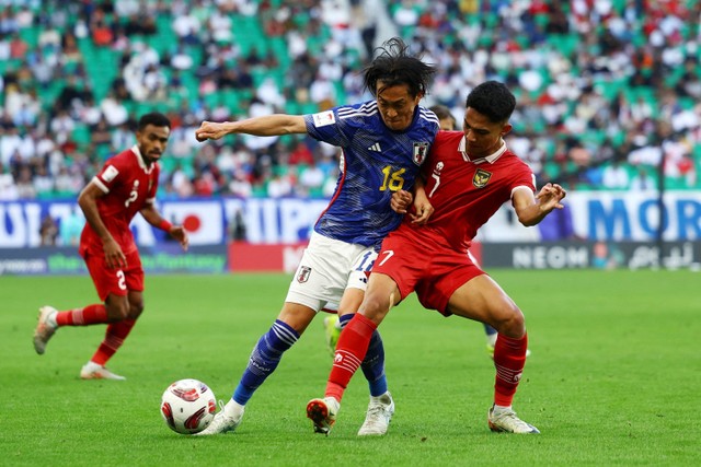 Pemain Timnas Indonesia Marselino Ferdinan berebut bola dengan pemain Timnas Jepang Seiya Maikuma pada pertandingan Grup D Piala Asia 2023 di Stadion Al Thumama, Doha, Qatar, Rabu (24/1/2024). Foto: Molly Darlington/REUTERS