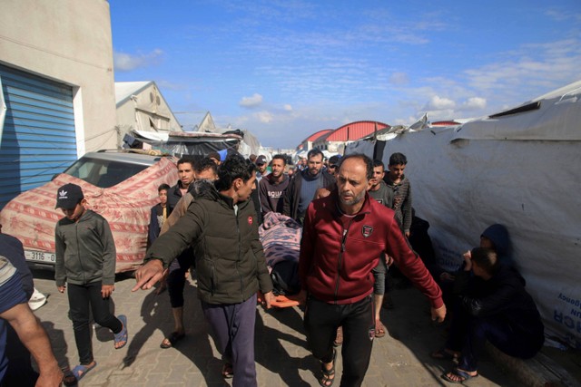 Warga Palestina membawa jenazah korban tewas serangan tank Israel ke gedung pusat pelatihan kejuruan UNRWA yang digunakan para pengungsi sebagai tempat berlindung di Khan Younis, Jalur Gaza selatan, Rabu (24/1/2024). Foto: Ramez Habboub/AP PHOTO