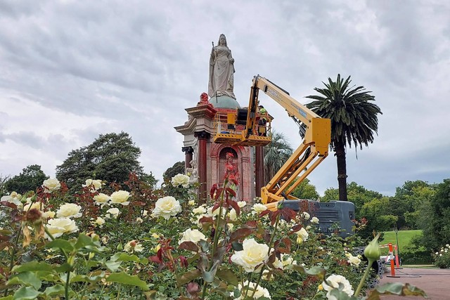 Seorang pekerja dewan membersihkan patung Ratu Victoria dari Inggris yang dirusak di Royal Botanic Gardens Victoria di Melbourne, menjelang Hari Australia, Kamis (25/1/2024). Foto: Martin Parry/AFP