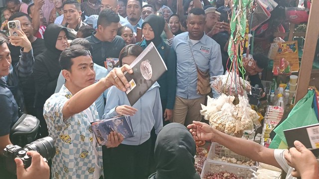 Cawapres nomor urut 02, Gibran Rakabuming Raka blusukan ke Pasar Pharaa Sentani, Jayapura, Papua, Jumat (26/1).  Foto: Zamachsyari/kumparan